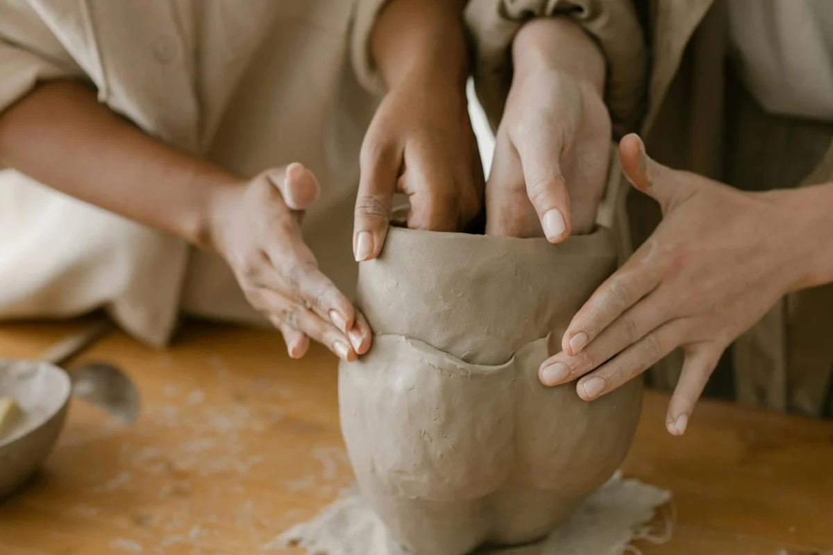 Close-up of hands shaping a clay pot, illustrating careful, step-by-step mold removal and enclosure sanitation.
