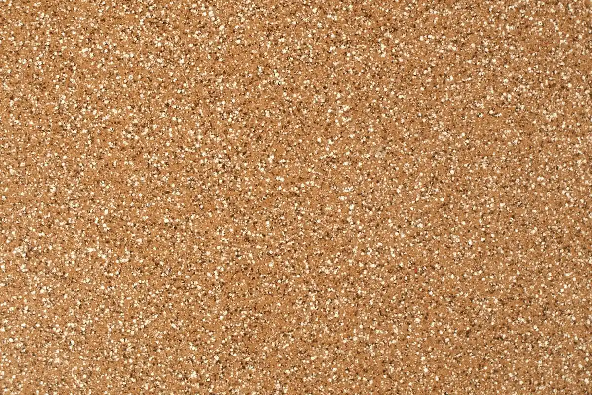 Close-up of sandy substrate texture for a hermit crab tank, showing fine-to-medium grains with small white particles.